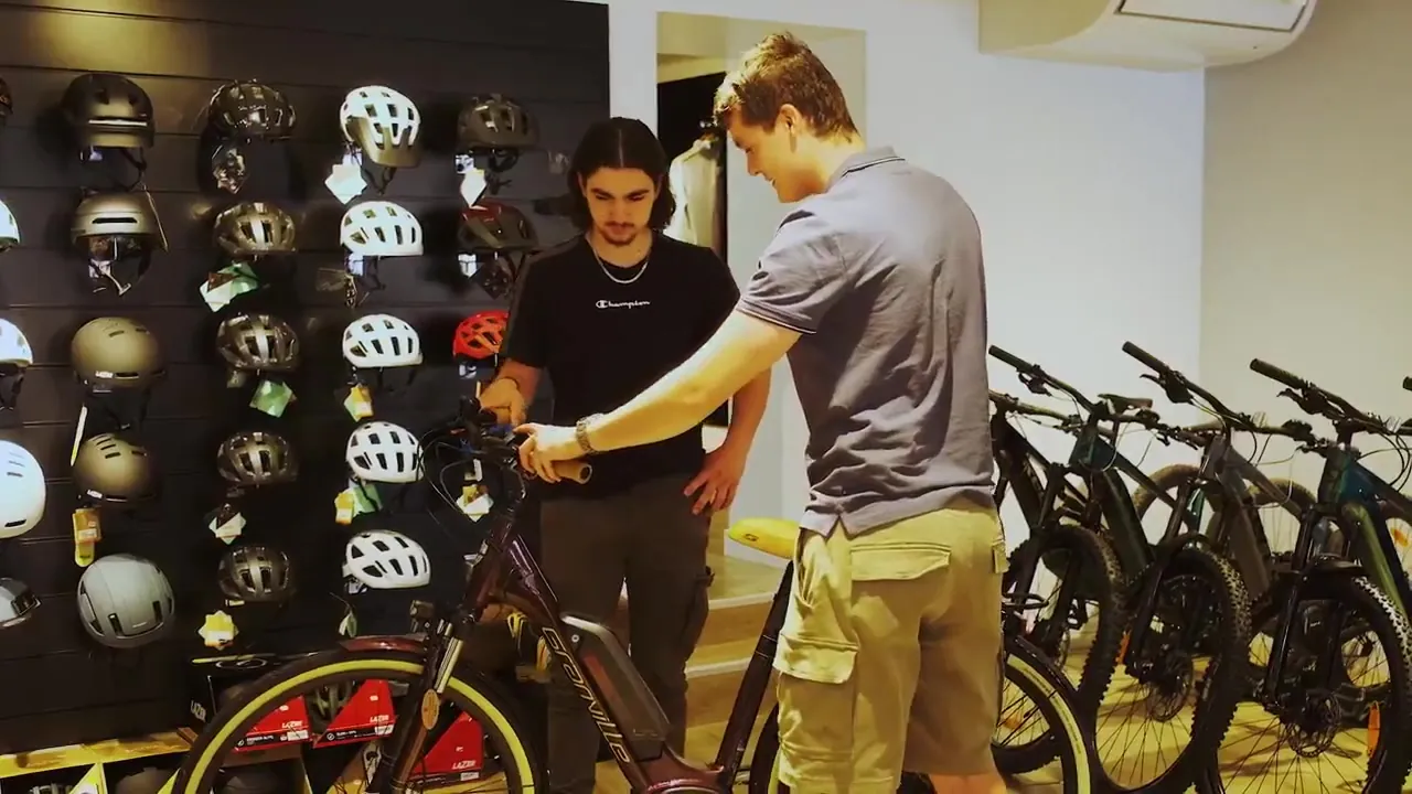 Conseil au magasin Vélo Shop, devant le mur de casques