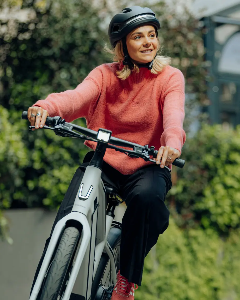 Cycliste souriante sur un speed pedelec Stromer ST2 blanc, en ville