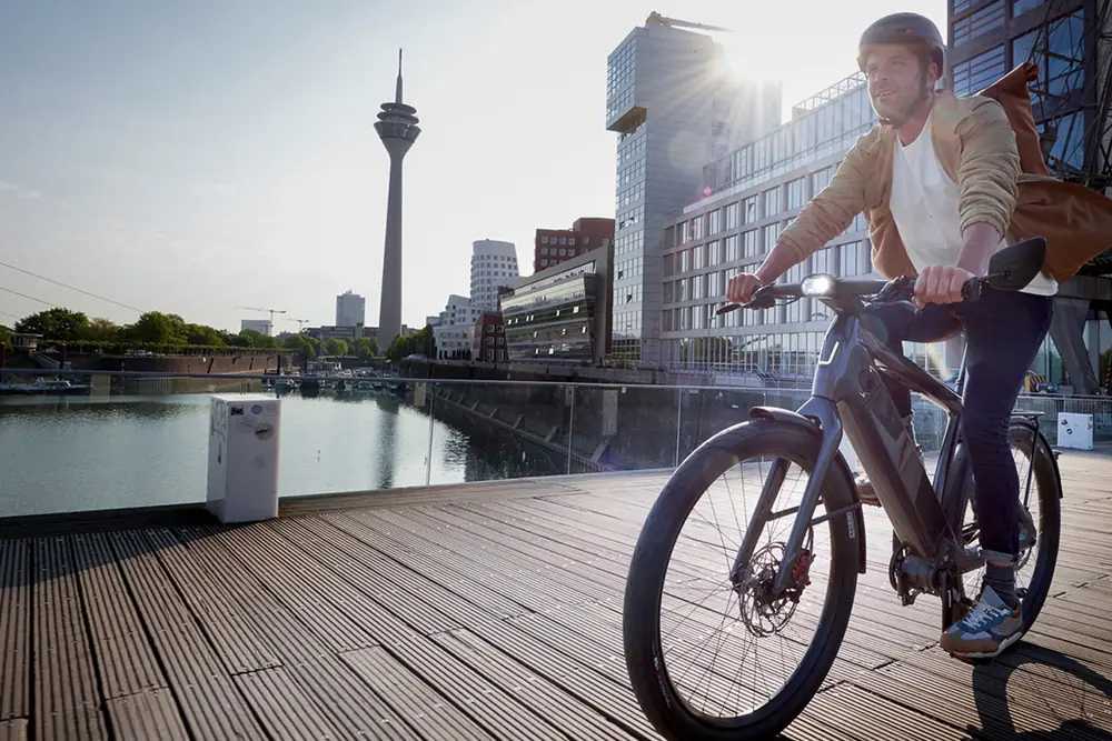 Cycliste sur un Stromer ST7 au bord de l'eau, en ville